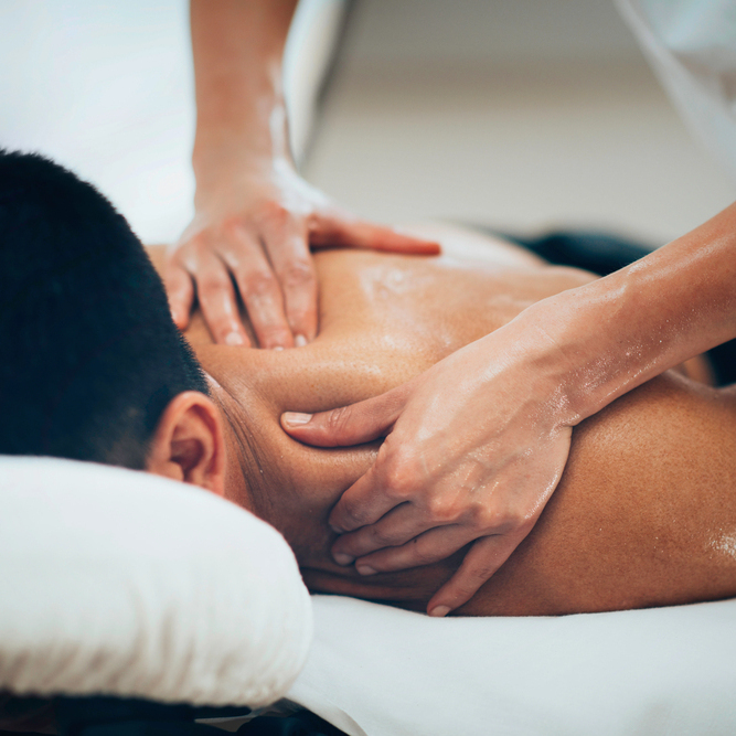 Physical therapist doing massage of male's shoulder